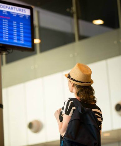 woman front airport flight information panel (1)